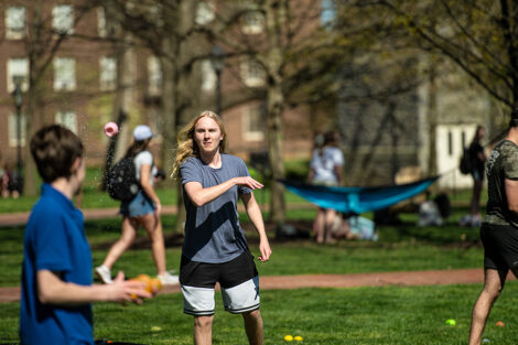 Students throw water balloons at each other.