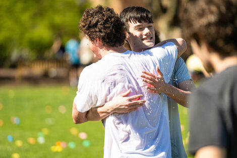 Students throw water balloons at each other.