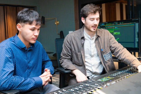 Two students sitting in an recording studio.