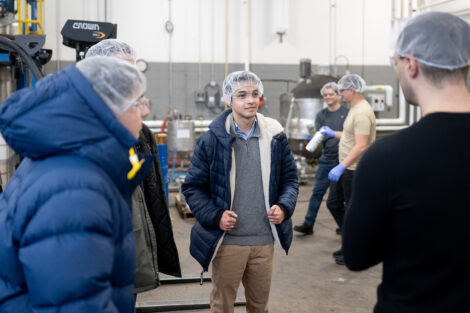 A group of students standing within industrial factory grounds
