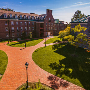 Brick walkway leading to McKeen residence hall with Farinon College Center in the right corner.