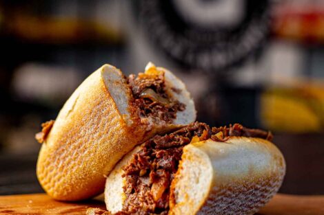 A cheesesteak is shown with Giacomo's branding in the background.