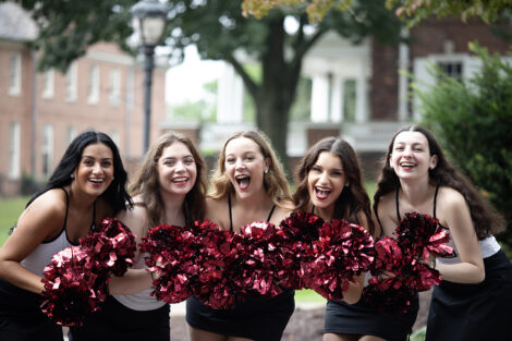 Students smile with pom poms.
