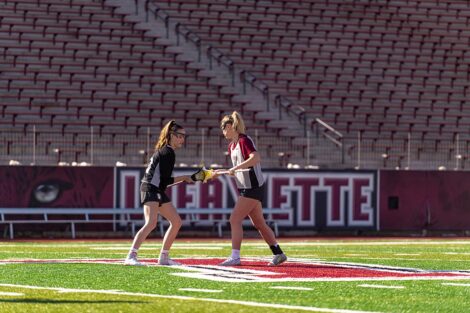 Two lacrosse players in action