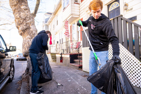 Students collect trash while volunteering in the community.
