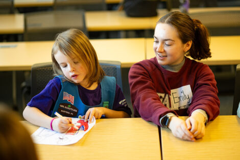 A Lafayette students sits alongside an elementary student