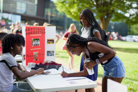 A student signs up for a club during an involvement fair